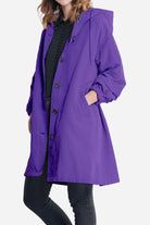 Purple water resistant oversized windbreaker jacket with hood and button closure for women