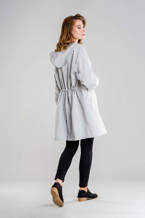 Gray oversized water-resistant windbreaker jacket with hood worn by a woman