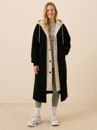 Woman wearing black oversized sherpa-lined long coat with hoodie, casual outfit for everyday wear oversized coat.