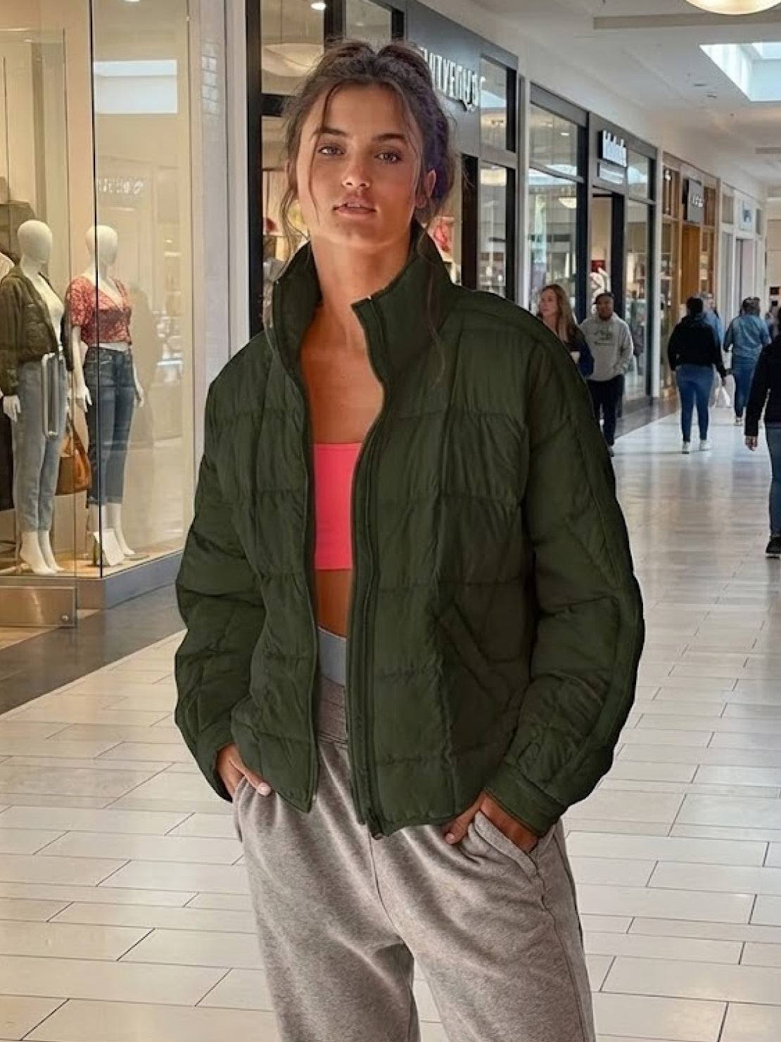 woman wearing olive green lightweight puffer travel jacket in shopping mall