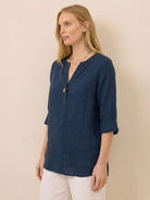 Woman wearing navy pure linen age-defying button detail shirt with three-quarter sleeves.