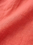 Close-up of coral pure linen fabric for age-defying button detail shirt