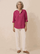 Woman wearing pure linen age-defying shirt with button detail, standing outdoors