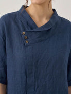 Lightweight 100% linen relaxed V-neck top with asymmetric button design and short sleeves in cream color