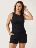 Woman wearing a high-neck ruched tankini set with gathered side seams and built-in brief at the beach
