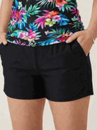 woman wearing high-neck ruched tankini set with gathered side seams and soft built-in brief at beach