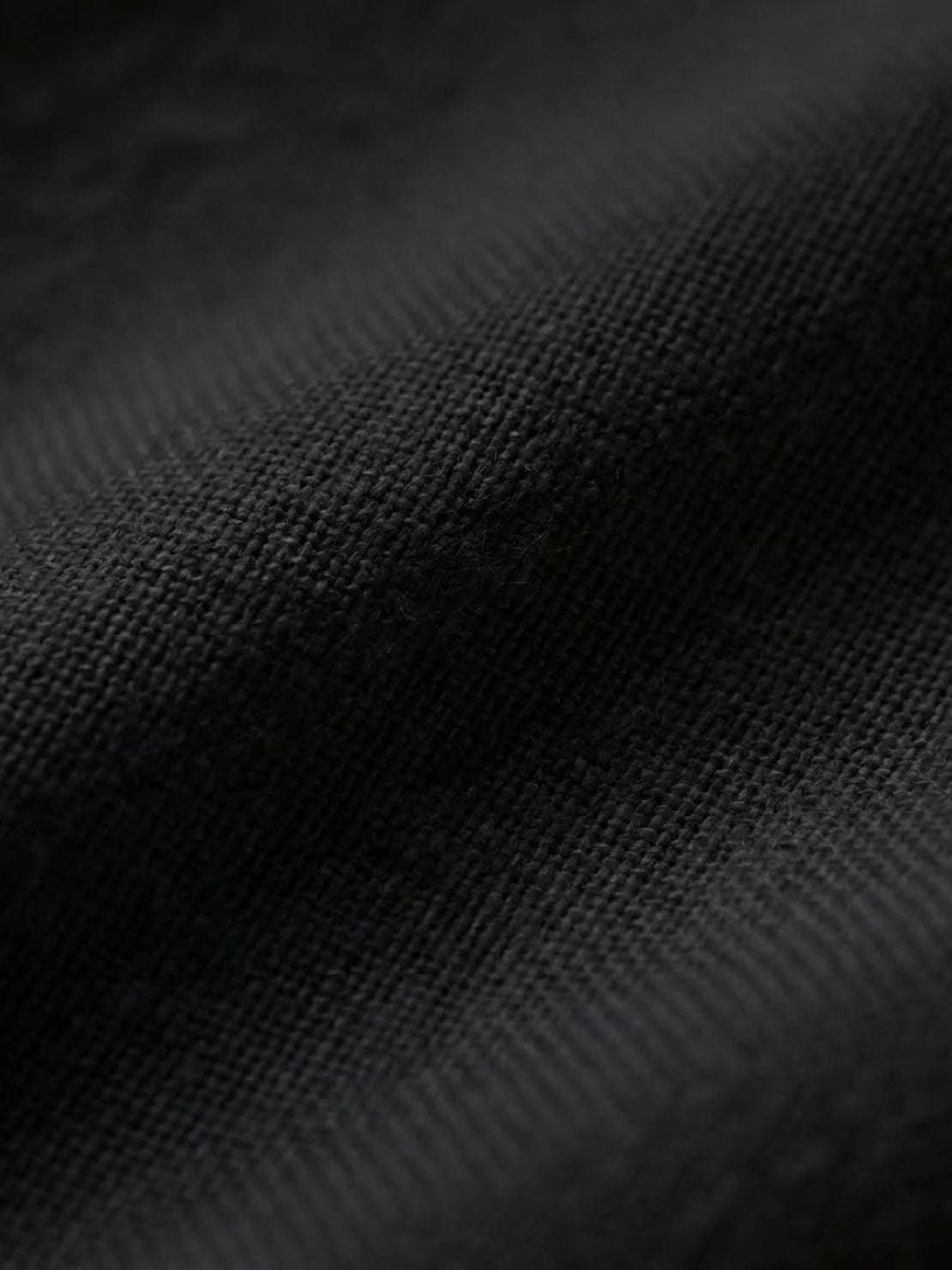 Close-up of soft black cotton fabric for short-sleeved pullover and wide trouser matching set