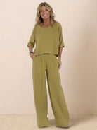 Woman wearing olive green short-sleeved pullover and wide trouser matching set, relaxed fit, breathable cotton fabric