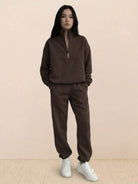Woman wearing a cotton-blended two-piece tracksuit with high collar and deep zipper, showcasing athleisure comfort and style.