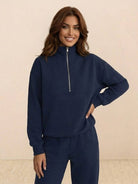 Woman wearing a cotton-blended two-piece tracksuit with high collar and deep zipper in monochrome color