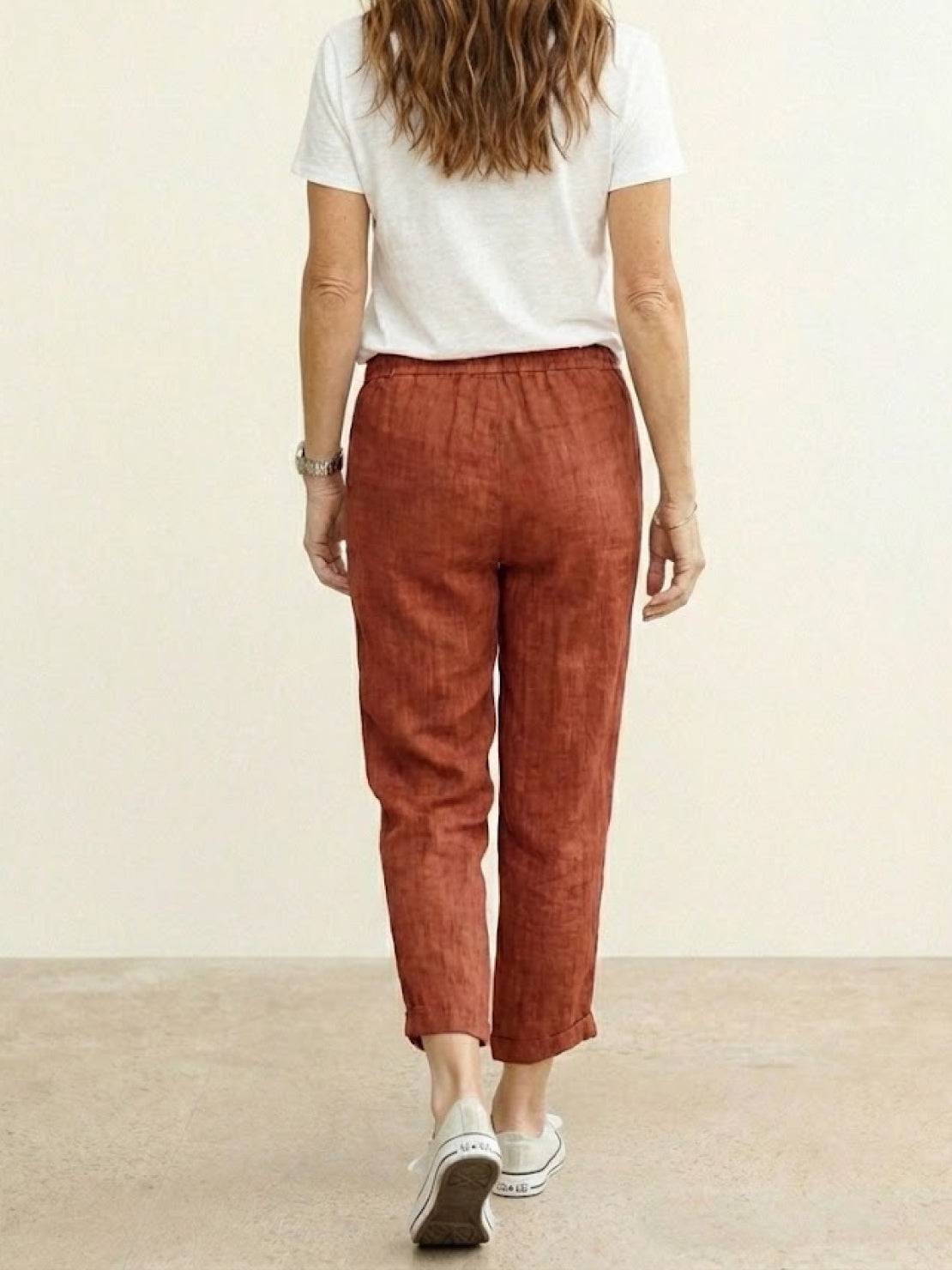 Woman wearing breezy relaxed fit straight pants in orange, styled casually for all-day comfort