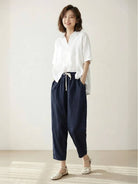 woman wearing orange relaxed fit straight pants standing on a street with hands in pockets