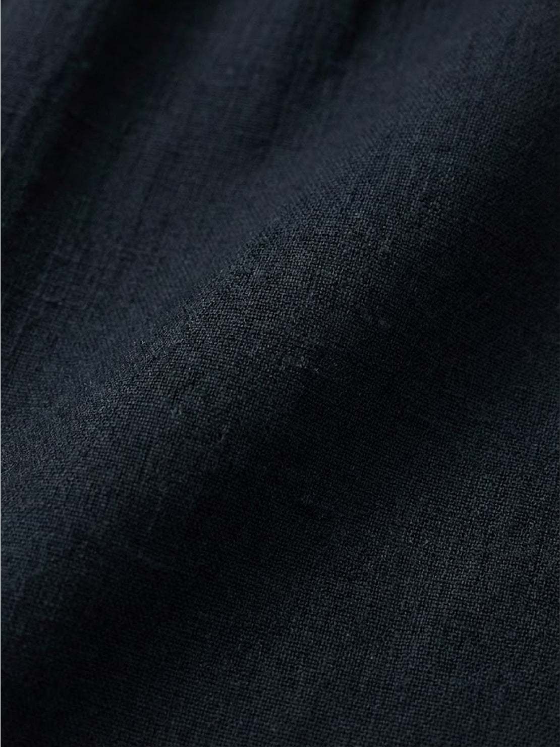 Woman modeling capped-sleeve voluminous pleated midi dress with pockets and flowing silhouette