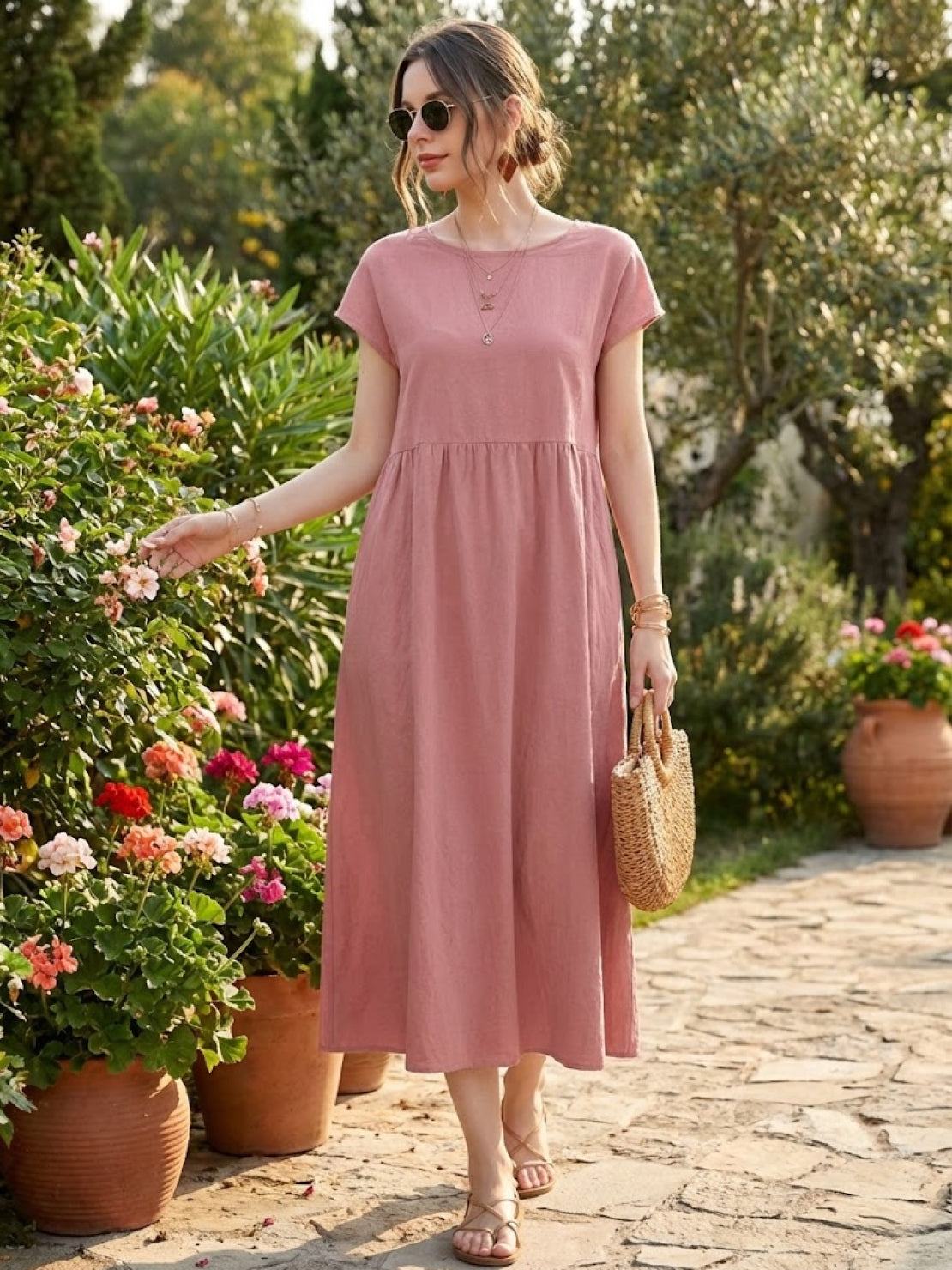 Woman wearing capped-sleeve voluminous pleated midi dress with flowing skirt and pockets