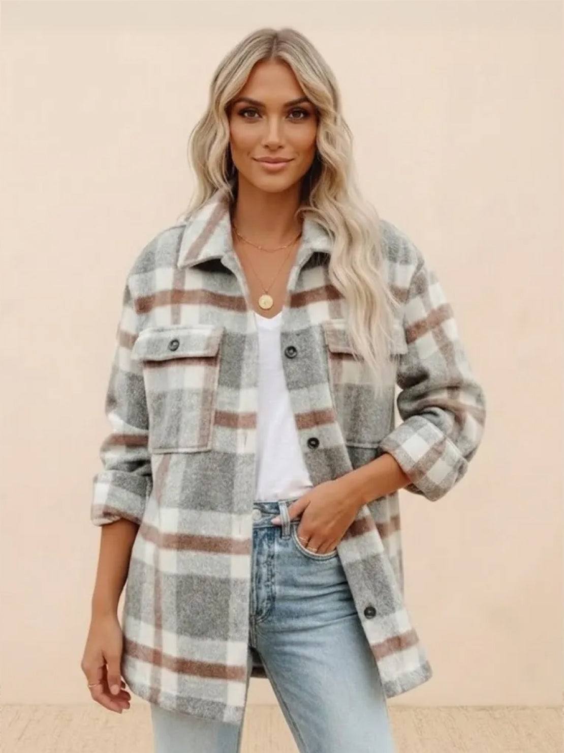 Woman wearing a comfy flannel classic button-down shirt in gray and brown plaid with rolled sleeves and casual jeans