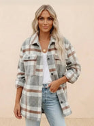 Woman wearing a comfy flannel classic button-down shirt in gray and brown plaid with rolled sleeves and casual jeans