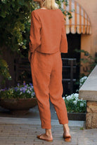 Back view of relaxed cotton-linen monochrome set with longline top and wide-leg pants in rust color.