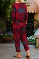 woman wearing cotton-linen monochrome red and black checkered relaxed longline top and fluid wide-leg pants outfit back view
