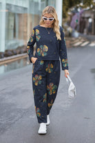 woman wearing dark cotton-linen monochrome capsule outfit with colorful floral prints walking on street with white sneakers and sunglasses