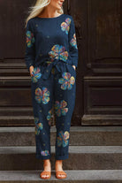 woman wearing navy cotton-linen floral print relaxed longline top and wide-leg pants set with colorful flowers