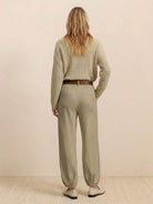 Woman wearing European minimalism relaxed sweater top and khaki trousers set, back view