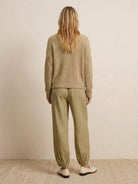 Back view of relaxed sweater top and trouser set in neutral tones embodying European minimalism style