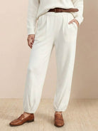 White relaxed knit trousers styled in European Minimalism fashion with casual loafers and belt