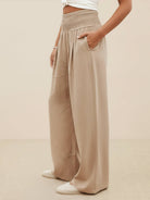 Beige high-waist palazzo pants with wide legs and pockets, made of breathable cotton linen blend
