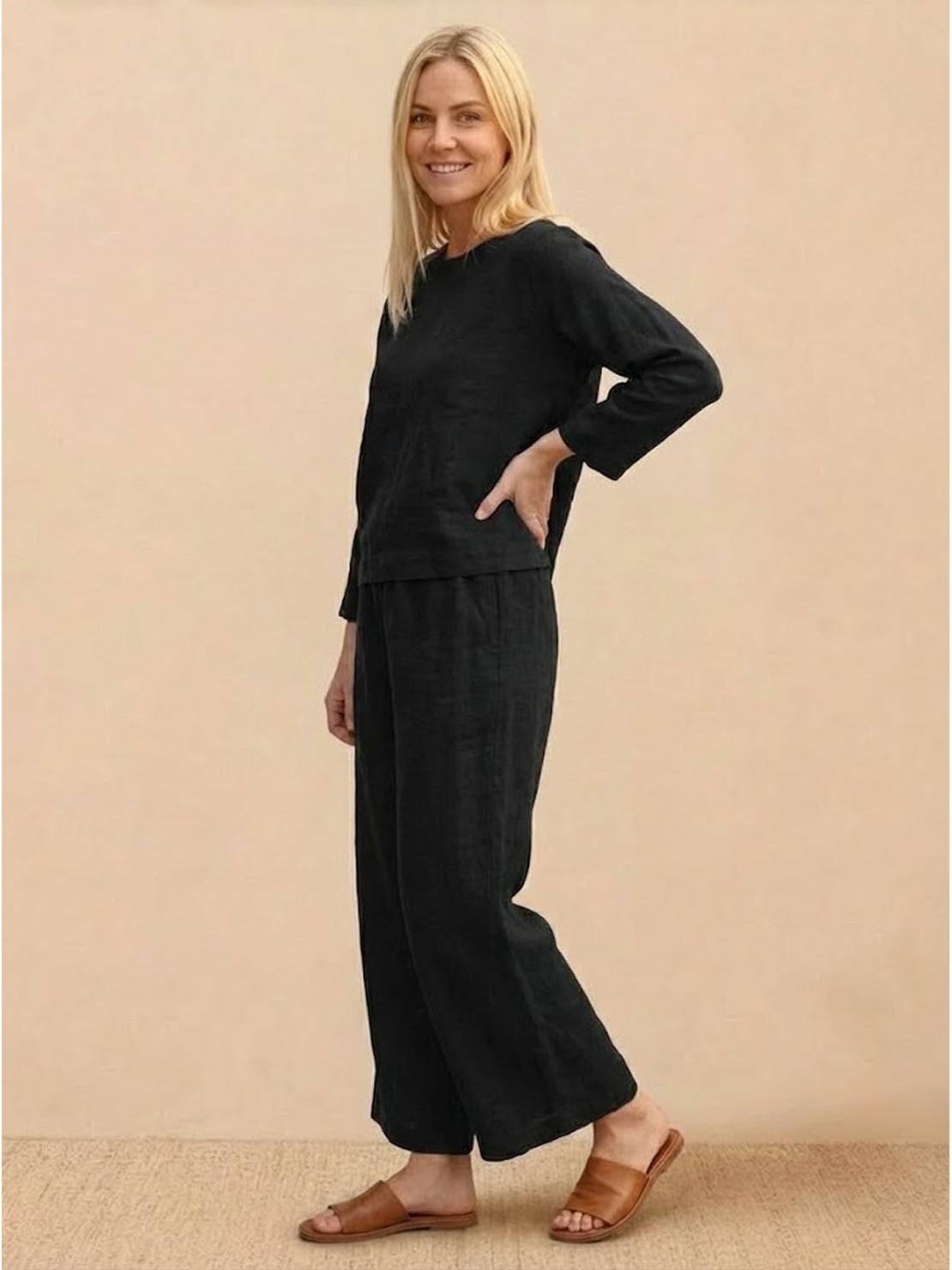 woman wearing loose solid color black two-piece set with long sleeves and wide-leg pants