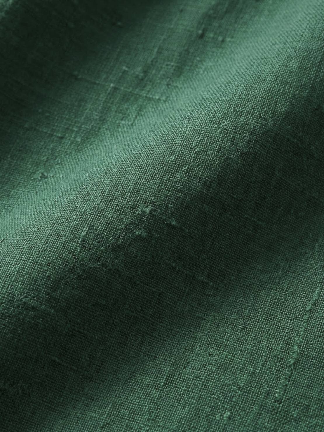 close-up of green loose solid color breathable cotton blend fabric texture