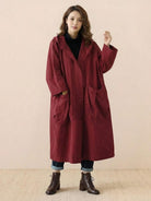 Woman wearing a one size fits all oversized water resistant windbreaker jacket with waterproof design in burgundy color