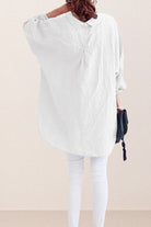 Back view of a woman wearing an oversized white linen and cotton blend shirt with relaxed fit and gathered back detailing
