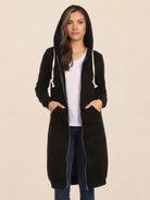 Woman wearing black oversized long zip sweatshirt hoodie with hood and front pockets