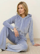 woman wearing modern cropped velour tracksuit with high-waist pants in vibrant color