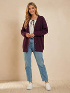 Relaxed fit oversized button down knitwear cardigan in deep plum on woman with casual jeans and white sneakers