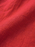 Close-up of vibrant red relaxed loose breathable linen fabric texture