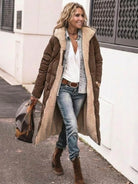 Woman wearing a brown sherpa-lined hooded teddy coat with jeans and boots walking outdoors