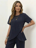 Woman wearing textured elegance two-piece set with asymmetrical top and wide-leg pants