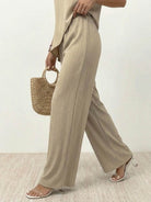Woman wearing Textured Elegance two-piece set with asymmetrical top and wide-leg pants