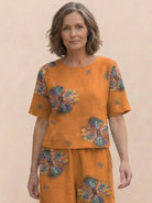 Woman wearing a loose fit co-ord set with soft-tailored top and wide-leg bottoms in solid color