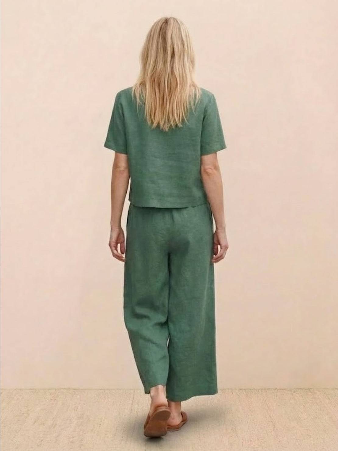 Woman wearing green loose fit co-ord set with wide-leg trousers and short-sleeve top, back view