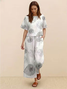 Woman wearing loose fit co-ord set with floral print, wide-leg trousers, and relaxed short-sleeve top.