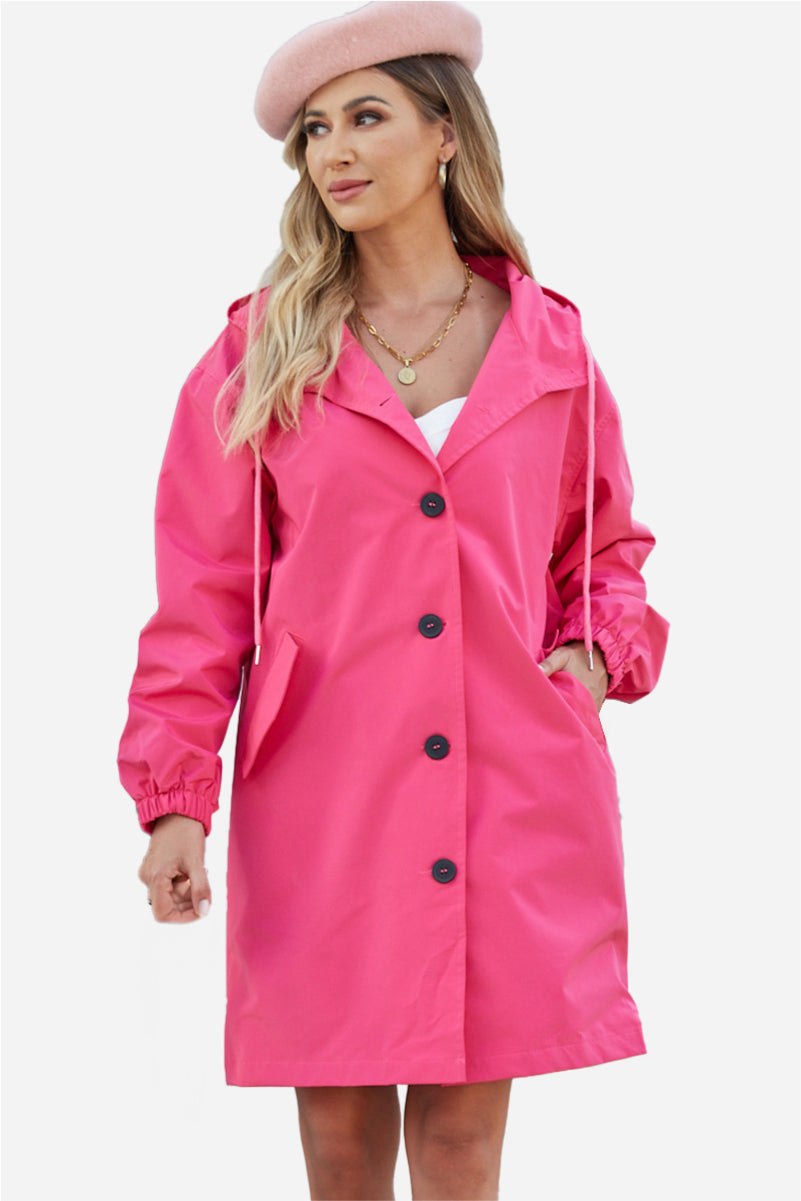 Woman wearing vibrant pink Rain Couture Windbreaker oversized water-resistant jacket with button closure and hood