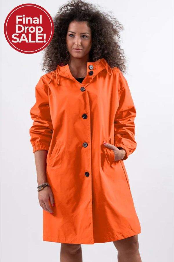 Woman wearing orange oversized Rain Couture Windbreaker jacket with buttons and pockets