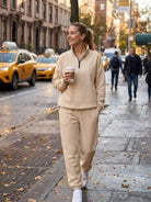 Woman wearing ultra-soft and comfy co-ord tracksuit set walking outdoors with coffee cup