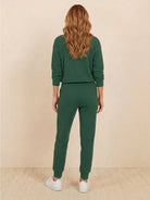 Unisex half-zip pullover and matching sweatpants set in soft, flexible fabric for casual comfort and relaxed fit